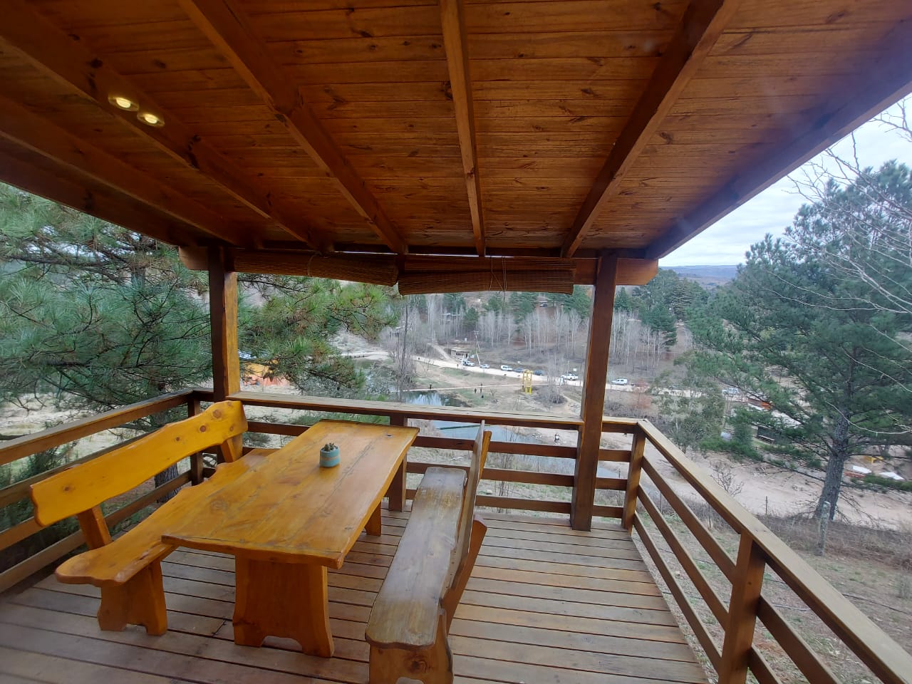 Deck exterior <br> Mesa y bancos en madera <br> Cortinas desplegables en mimbre